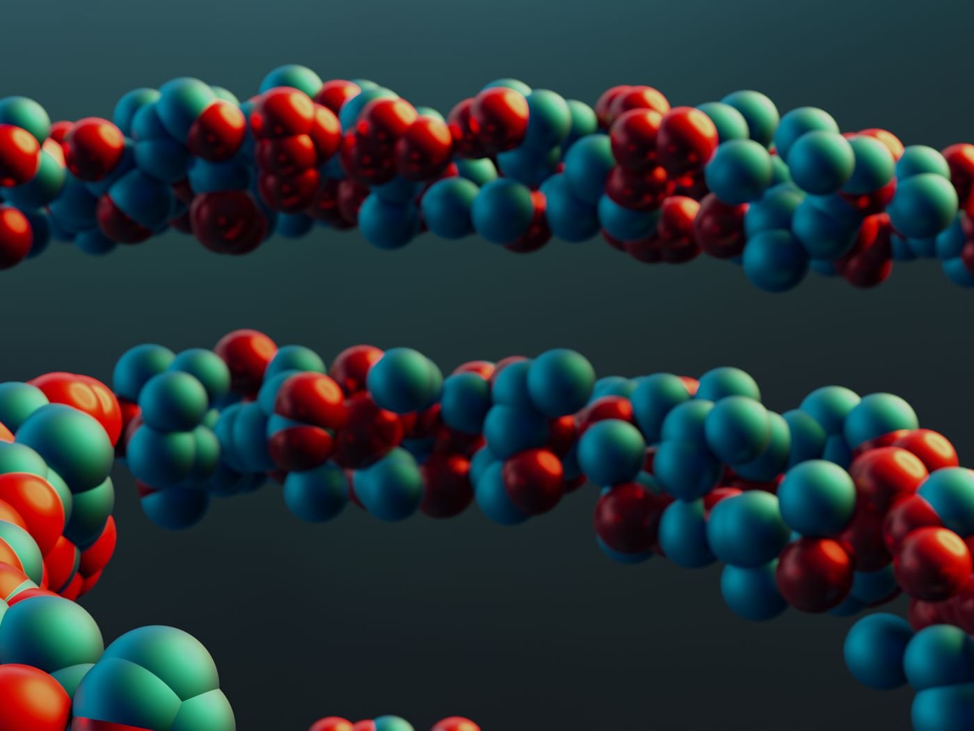 Modelo molecular de esferas brillantes unidas por varillas, en tonos rojo, azul y verde sobre fondo oscuro.