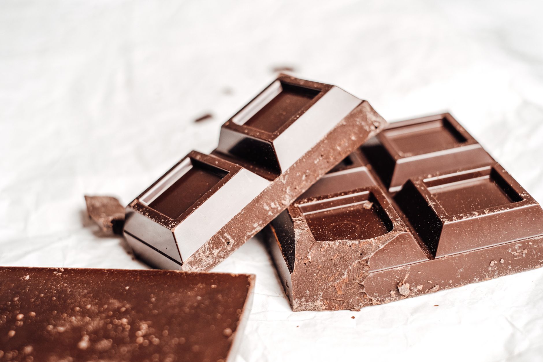 Trozos de tableta de chocolate repartidos sobre una superficie clara