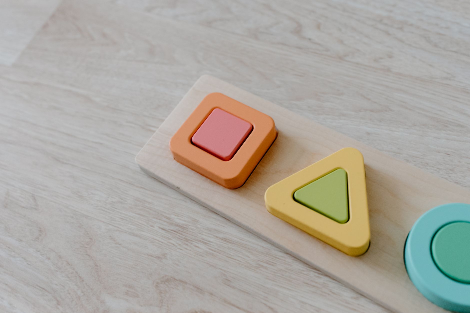Bloques de madera con formas cuadrada y triangular sobre fondo blanco