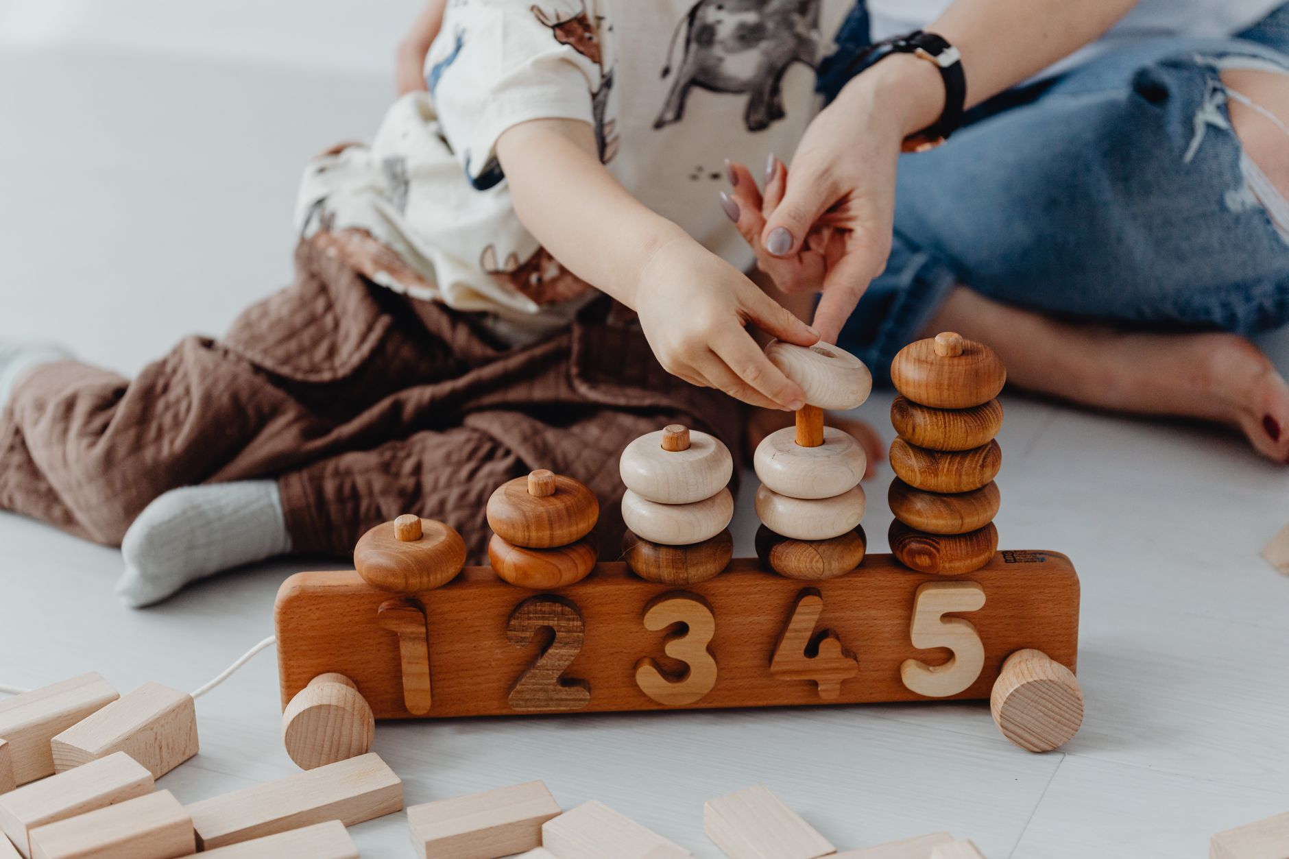 Madre e hijo jugando con juguetes de madera con números
