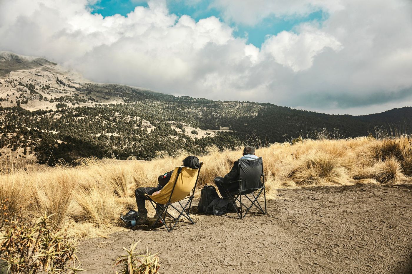 Dos personas observan el valle de montaña desde un punto elevado de la comunidad.