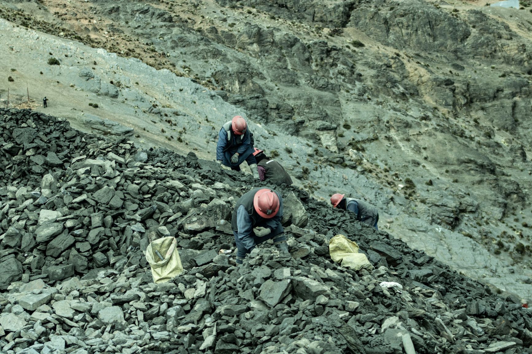 trabajadores con cascos recolectando piedras en una cantera rocosa, vista aérea
