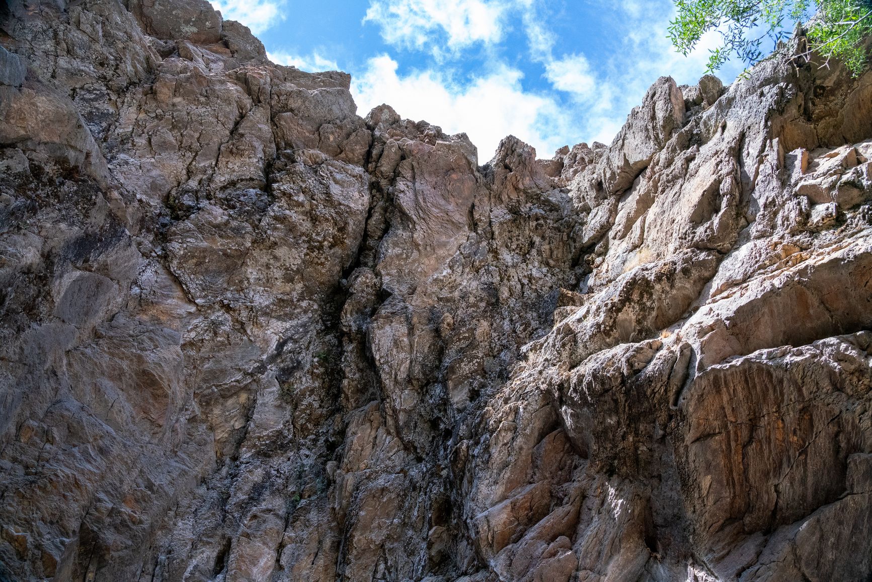 dos paredones de roca gris agrietada que enmarcan el cielo azul en una garganta de montaña