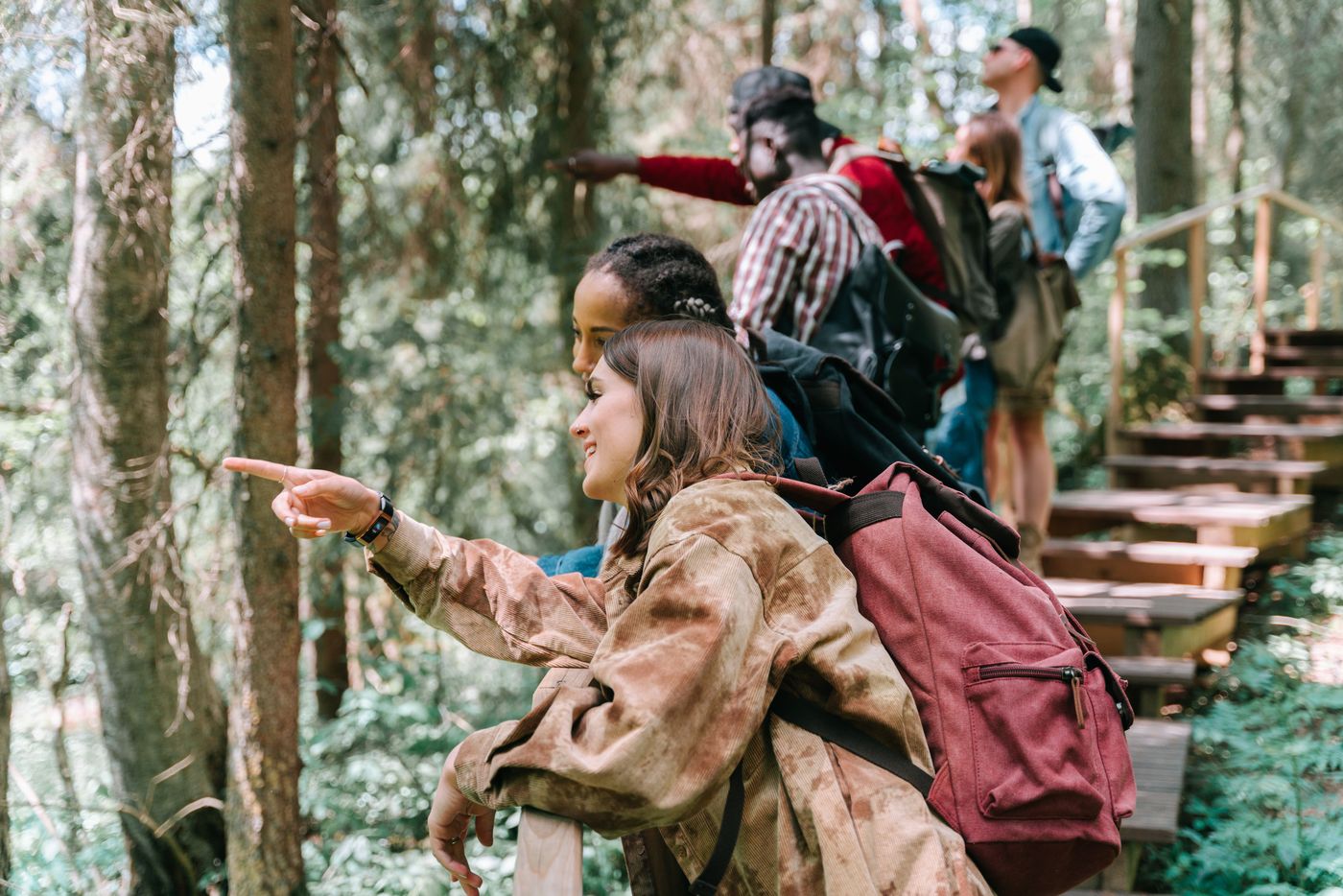 Grupo de estudiantes recorre un sendero de bosque y observa el entorno natural de su comunidad.