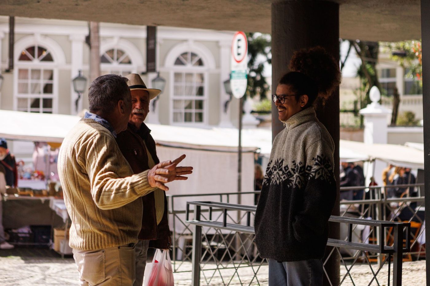 un grupo de vecinos conversa de pie en la plaza de su comunidad