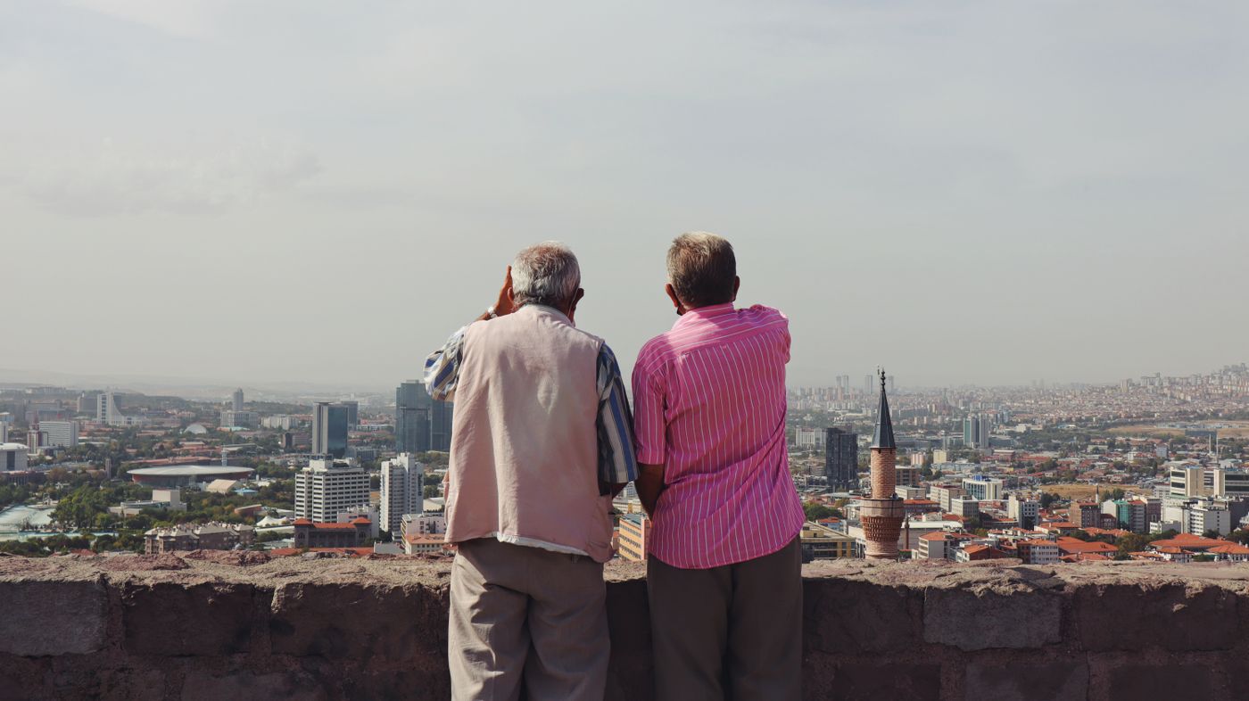 dos personas adultas contemplan el horizonte de la ciudad desde un punto alto