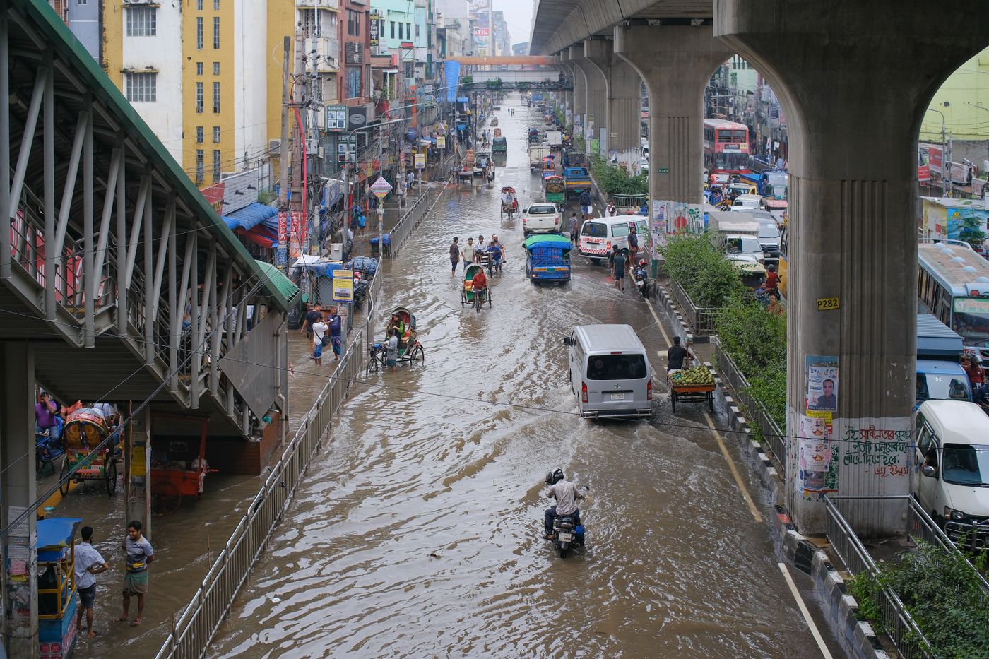 una calle de la ciudad con agua acumulada y vehículos después de la lluvia