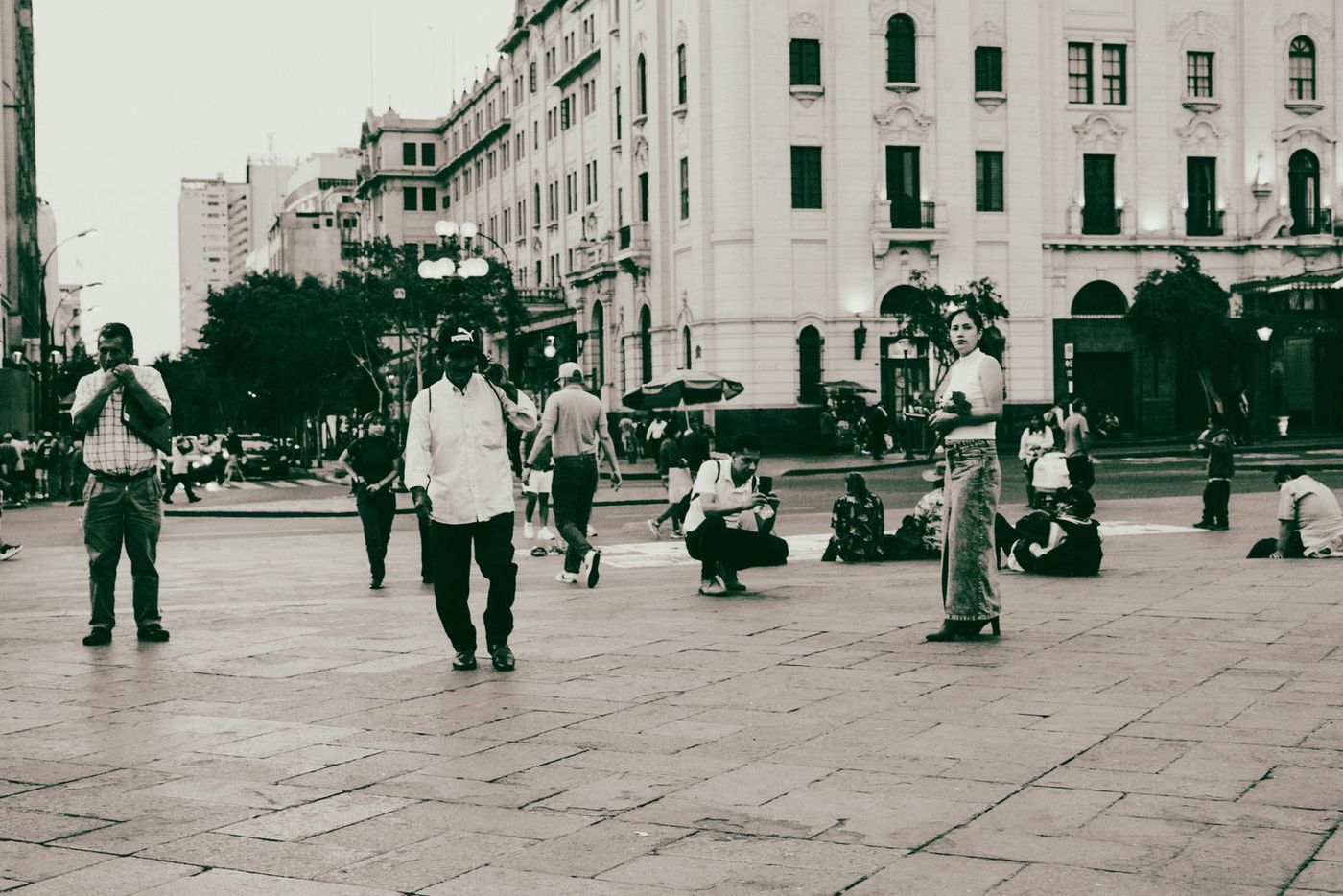 varias personas adultas caminan y conversan en la plaza del pueblo