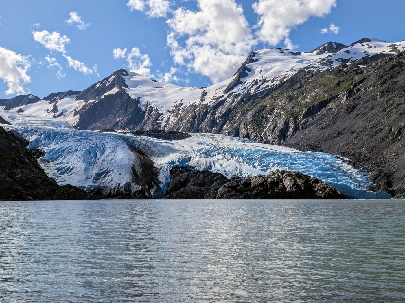 la lengua de un glaciar desciende entre montañas nevadas