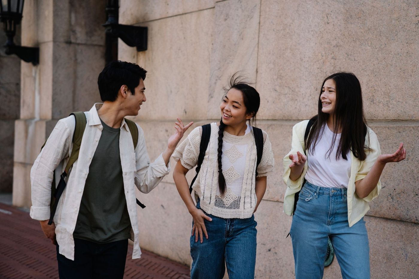 tres estudiantes caminan por una calle de piedra de una ciudad histórica y conversan sobre el comercio medieval