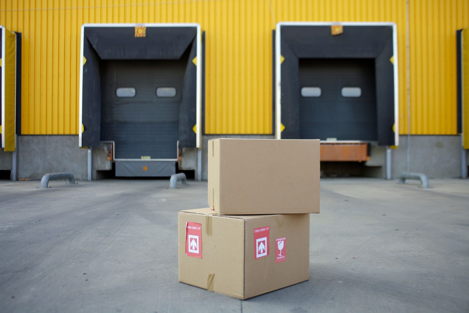 Cajas de cartón apiladas frente a los muelles de carga de una bodega industrial