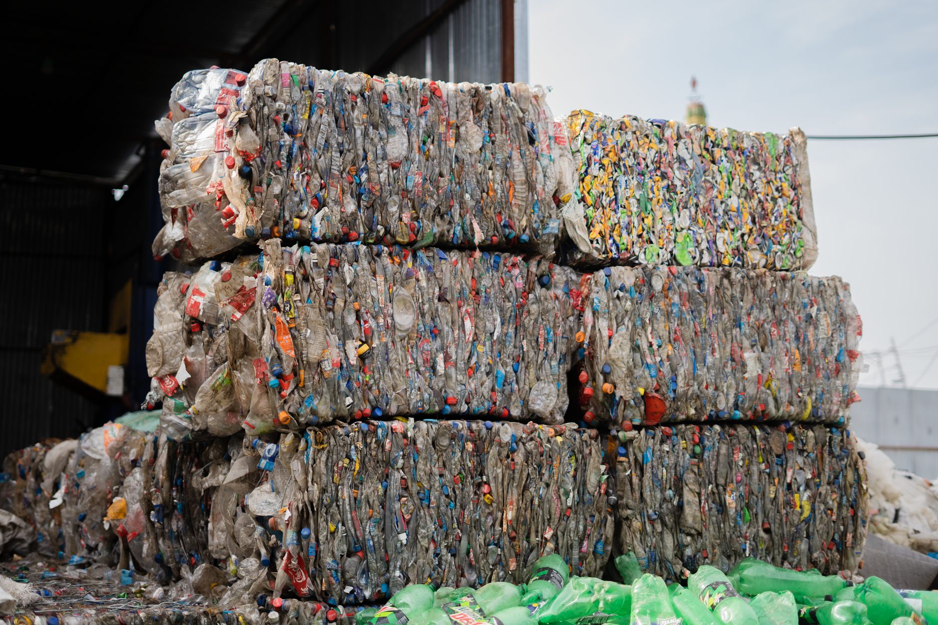 Pacas de botellas de plástico comprimidas apiladas en una planta de reciclaje.