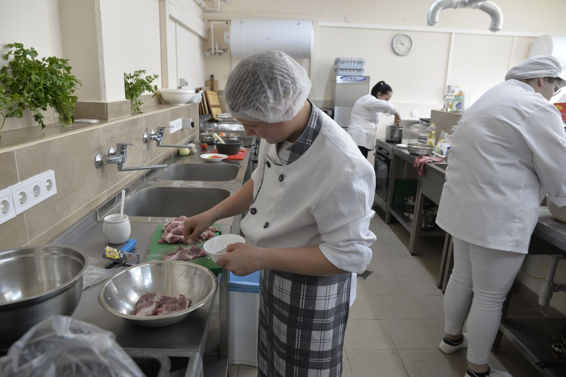 Estudiantes de cocina durante una clase de preparación de alimentos en la cocina del centro