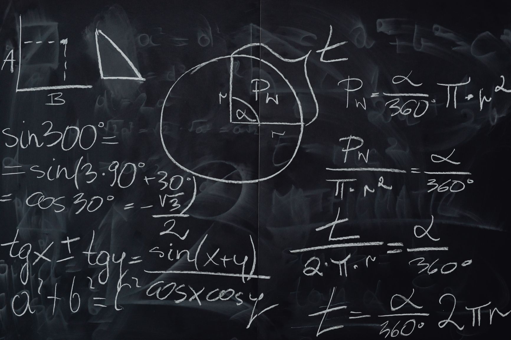 Pizarra oscura con fórmulas matemáticas escritas en tiza blanca, entre ellas expresiones trigonométricas, el teorema de Pitágoras y las fórmulas de un sector circular