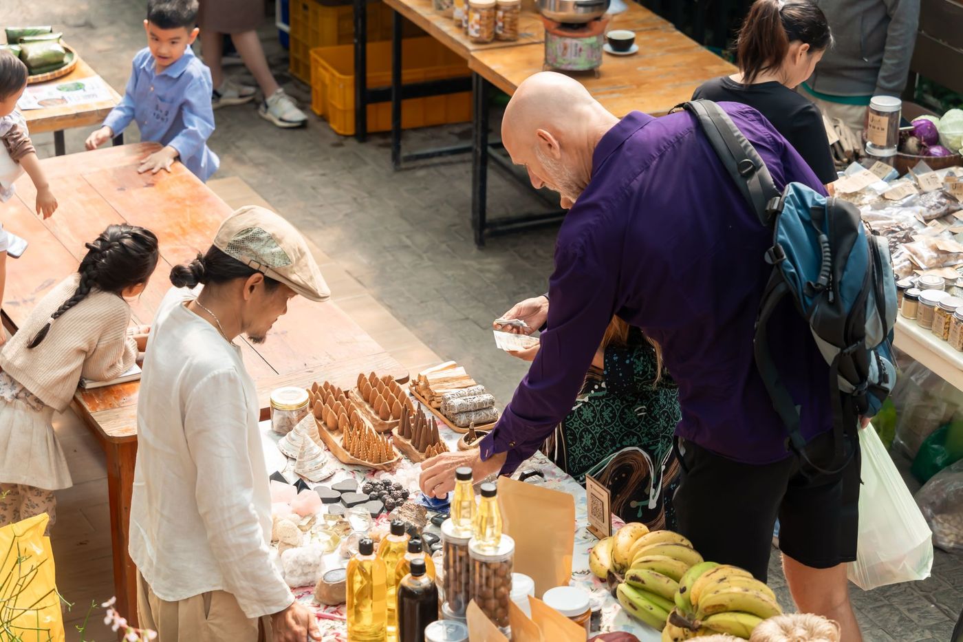dos personas conversan junto a un mercado al aire libre sobre el intercambio de productos